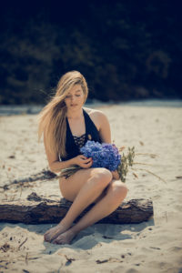 Con las flores en el tronco de la playa